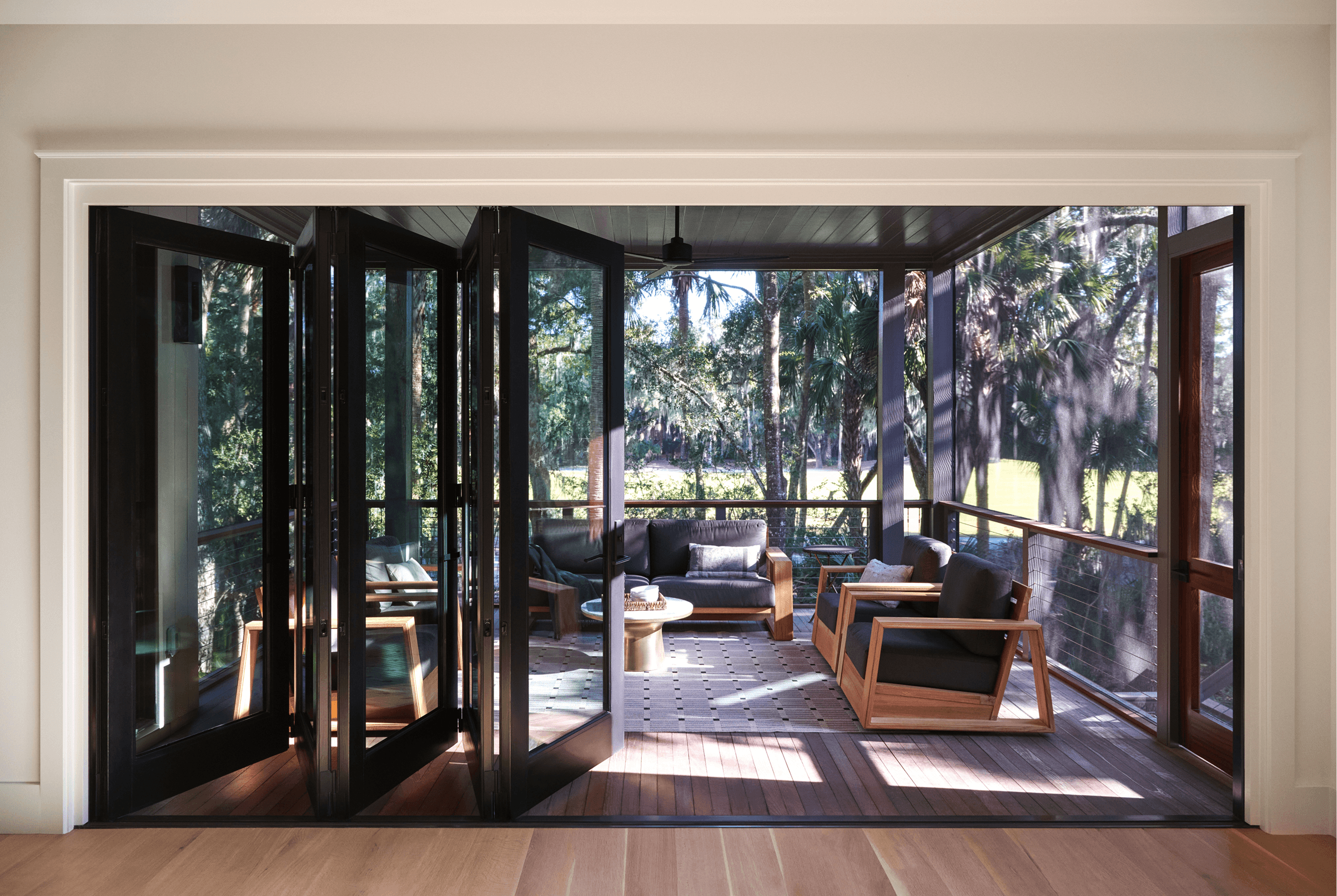 Interior view of an opened Marvin Ultimate Bi-Fold door leading to a three-season porch.