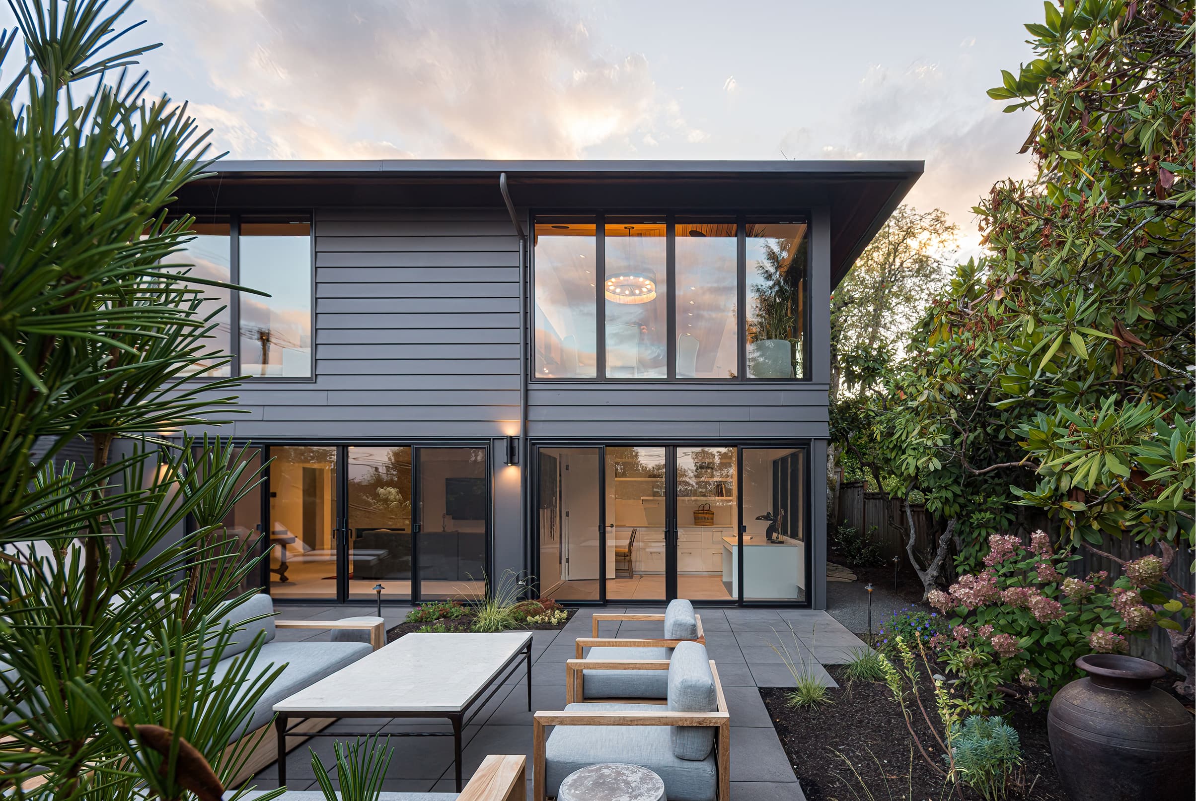 Gray home exterior with two black Marvin Elevate Sliding Doors and Ultimate Casement windows.