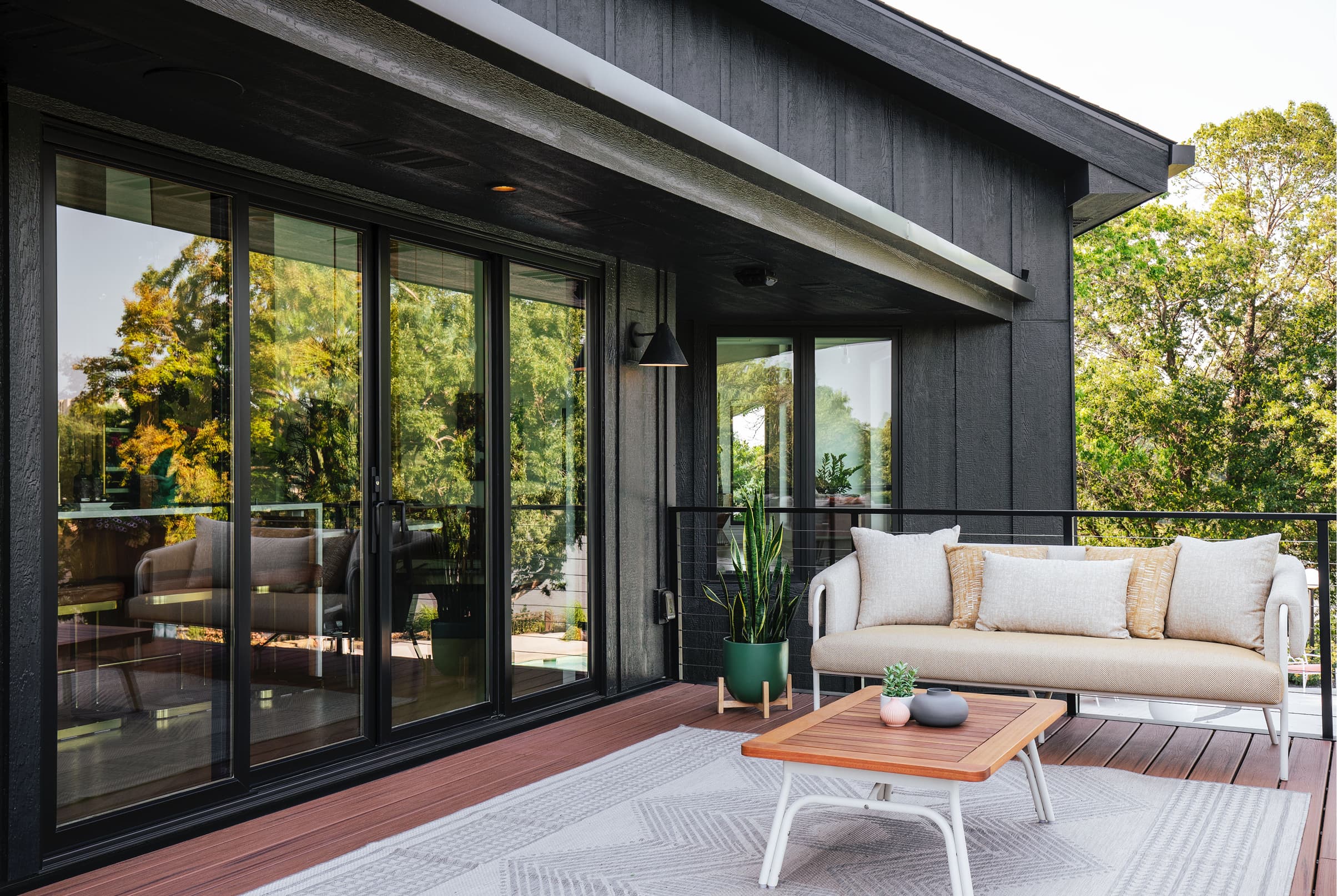 Home deck exterior with a black four-panel Marvin Elevate Sliding Door.